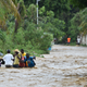 People try to cross the overflowing La Rouyonne river in the commune of Leogane, south of Port-au-Prince, October 5, 2016. Haiti and the eastern tip of Cuba — blasted by Matthew on October 4, 2016 — began the messy and probably grim task of assessing the storm’s toll. Matthew hit them as a Category Four hurricane but has since been downgraded to three, on a scale of five, by the US National Hurricane Center (Image: Getty)